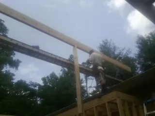 Carpenter setting a ridge beam over a new addition frame — Ice Dam Removal by Roofing Brothers in Durkee