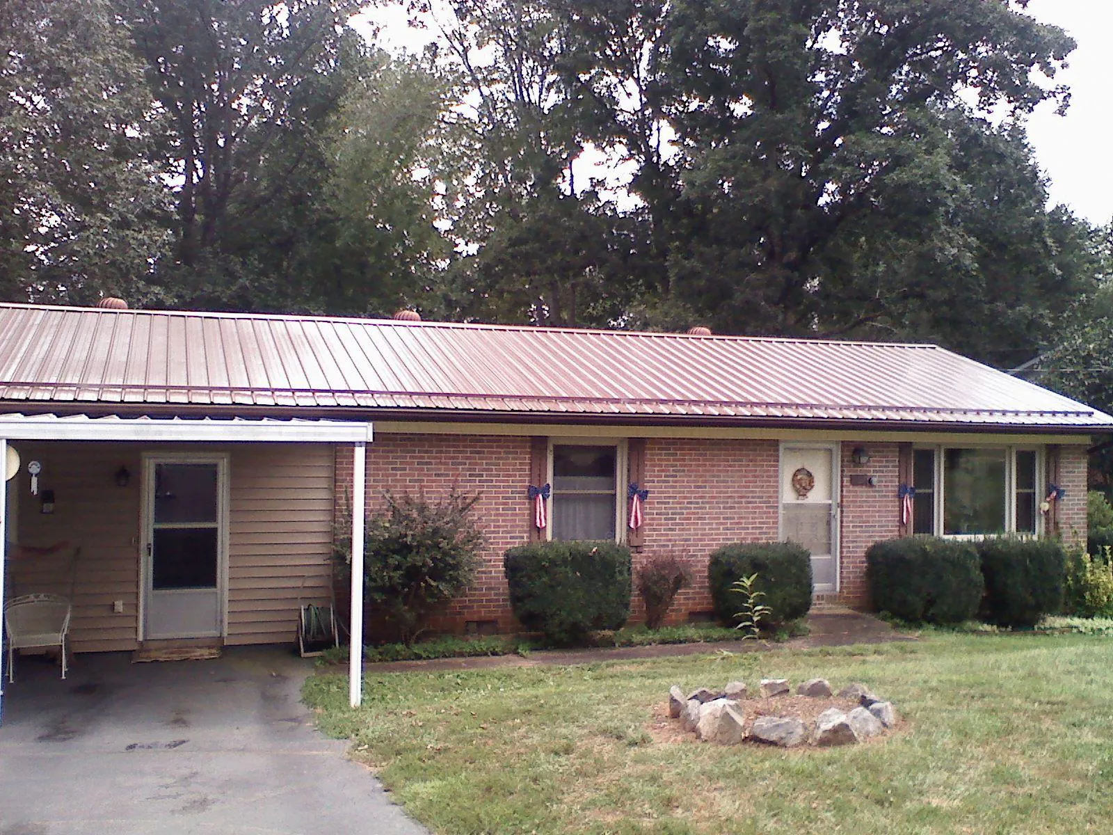 Bronze metal roof and carport on a brick ranch home — Roof Repair work by our crew in Durkee